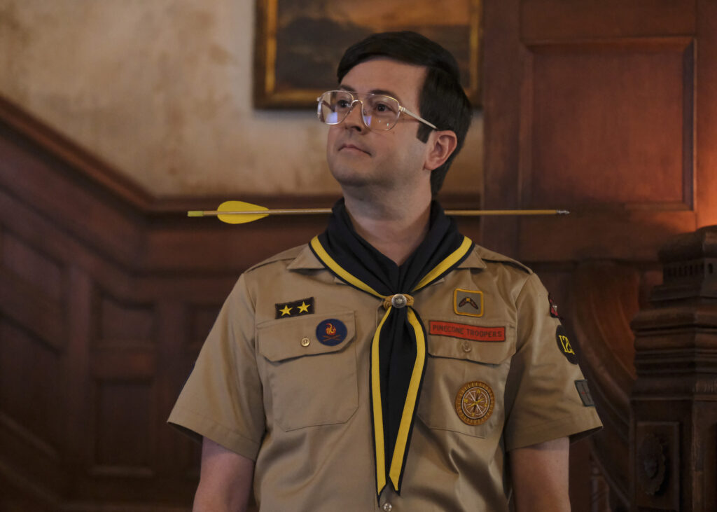 Picture of a TV Character dressed like a boy scout leader with an arrow through his neck.